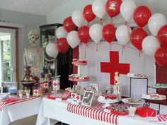 an image of a party with red and white balloons on the wall, candy bar table