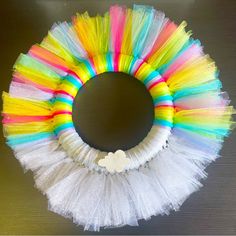 a colorful wreath made out of tulle with a white teddy bear on the front