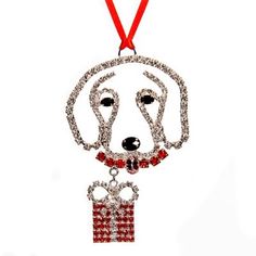 a beaded dog ornament hanging from a red ribbon on a white background