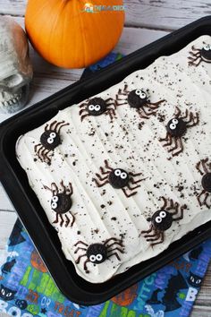 a halloween cake with white frosting and black spider decorations