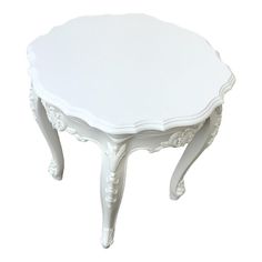 a white table with an ornate design on the top and bottom, sitting against a white background