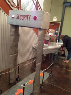 a security sign is taped to the side of a building with tape around it and two people standing in the background