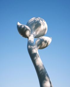 a white sculpture is in front of a blue sky