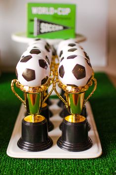 two soccer trophies sitting on top of each other