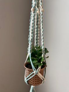 This classic hand-knotted macrame plant hanger is the perfect way to add a unique touch of boho to any room in your home. Each piece is handmade from 100% eco-friendly recycled cotton cord, featuring decorative wooden beads, a wooden ring hanger, and a beautiful tassel at the base. Fits most small to medium size pots or baskets. Perfect house warming gift for plant lovers! This plant hanger is for indoor use only and can be used to hang lightweight plants. Each piece is unique and may vary sligh Pot Hanger, Shepherds Hook, Perfect House, Wooden Ring, Wooden Rings, Apartment Ideas, Cotton Cord, Plant Pot, Knitting For Beginners