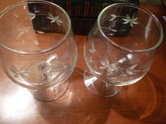 two clear glasses sitting on top of a wooden table