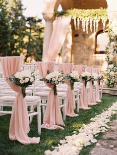 rows of chairs with pink sashes and white flowers