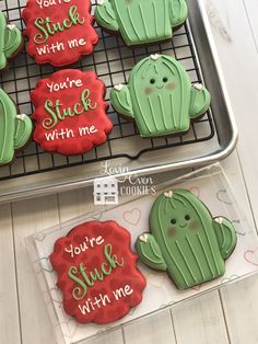 some cookies that have been decorated to look like cacti and are on a cooling rack