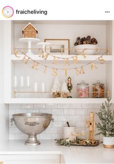 a kitchen shelf filled with christmas decorations and decorating on top of white counter tops