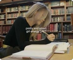 a woman sitting at a table in front of a bookshelf with a pen and paper