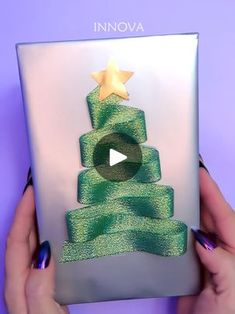 someone is holding up a card with a christmas tree on it, and the video below reads innova