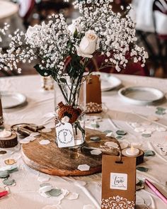 the table is set with flowers and place cards for guests to sit down at it