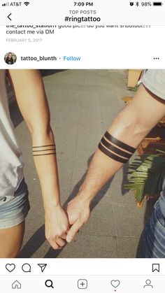 two people holding hands with tattoos on their arms