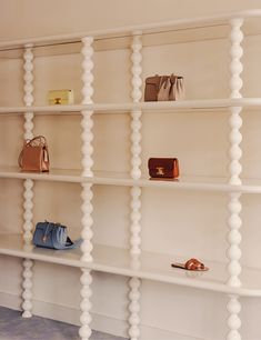 several white shelves with purses and handbags on them