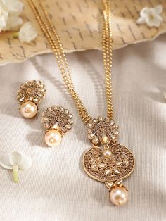 This jewellery set consists of a necklace and a pair of earrings22K Gold-plated multi-stranded necklace, has a beige Kundan-studded centerpiece with beaded droplet detail, secured with a hook closureA pair of matching drop earrings, secured with a post-and-back closure Size & Fit Necklace Length: 60 cmEarrings Length: 4 cm (Each) Material & Care AlloyWipe with a soft, lint-free clean clothAvoid contact with perfume, soap, hairspray, and cosmeticsAvoid using gold in swimming poolsStore your jewelry in a fabric-lined box to prevent the loosening of the stone setting Dispatch within 7 days Elegant Antique Gold Chandbali Necklaces, Elegant Gold Kundan Beaded Necklaces, Elegant Gold Kundan Beaded Necklace, Gold Jeweled Necklaces With Round Beads, Elegant Gold Beaded Jeweled Necklace, Elegant Long Beige Necklace, Gold Chandbali Necklaces With Pearl Drop, Gold Jewelry With Stone Work On Round Beads, Gold Chandbali Necklace With Pearl Drop