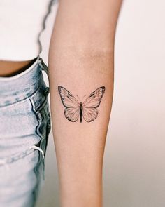 a woman's arm with a butterfly tattoo on the left side of her leg