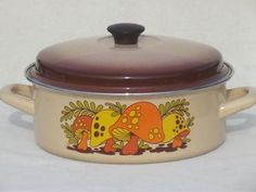 a casserole dish with an elephant painted on the side and brown trim around the lid