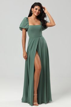 a woman in a long green dress with a slited skirt and thigh high heels