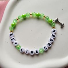 "Key Lime Green" bracelet, on a stretch chord - referencing The Last Great American Dynasty.  If there are any designs you are looking for but can't find, send me a message and I can create it for you.  **Due to the nature of the material of the beads, I recommend keeping your bracelets dry and away from water or chemicals when possible. The white and light color beads will show wear and tear/dirt quicker than the darker colors. Keeping the bracelets dry and away from lotions, chemicals, dyed garments, etc. will help keep them looking new for much longer.                                                                                                                  -Alyssa from LyssieBCreations The Last Great American Dynasty Bracelet, Handmade Inspirational Stretch Bracelet, Green Personalized Novelty Bracelets, Green Novelty Bracelets With Round Beads, Green Novelty Jewelry With Letter Beads, Novelty Stretch Bracelet For Friendship, Customizable Adjustable Green Bracelets, Novelty Adjustable Stretch Bracelet For Friendship, Adjustable Customized Green Bracelets