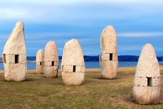 some very big rocks in the middle of a field with water in the back ground