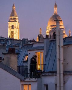 two people standing on the roof of a building