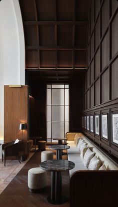 a living room filled with lots of furniture and walls covered in wooden paneled panels