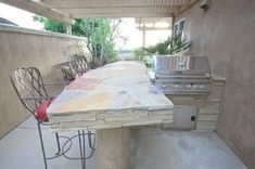 an outdoor kitchen with grill and seating area