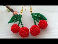 the beaded cherries are hanging from earrings