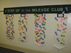 a sign that says step up to the mileage club hanging on a white wall