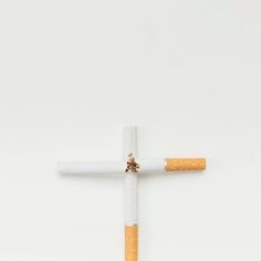 Cross sign made from broken cigarette over white background Cross Sign, White Background, Signs, White