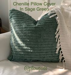 a green crocheted pillow sitting on top of a white couch