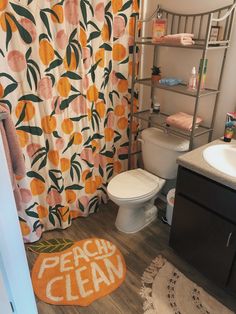 a bathroom with a toilet, sink and shower curtain that says peach clean on it