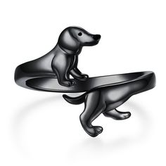 two dogs are sitting on top of each other's wedding bands, one is black and the other is silver