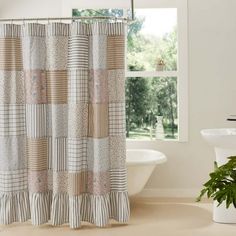 a bathroom with a bathtub, sink and shower curtain that has different colored squares on it