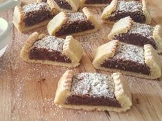 several pieces of pie sitting on top of a wooden cutting board