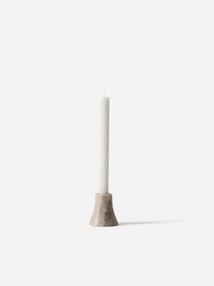 a tall white candle sitting on top of a table