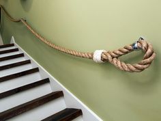 a rope hanging on the wall next to some stairs