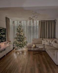 a living room filled with furniture and a christmas tree in front of a tv mounted on the wall