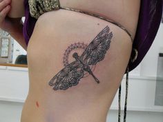 a woman's thigh with a tattoo design on the lower leg and an intricate dragonfly