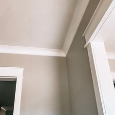 the corner of a room with white trim on the walls and ceiling is painted gray