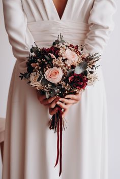 a woman in a white dress holding a bouquet of flowers