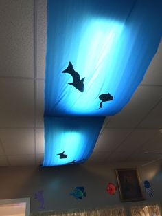 the ceiling is covered in blue fabric with dolphins on it