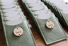 several pairs of scissors are sitting on top of each other in green felt cases with white buttons