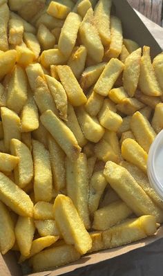 a box filled with french fries next to a container of dip