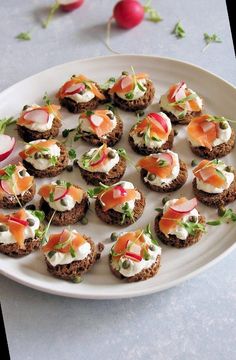 small appetizers are arranged on a plate with radishes and other toppings