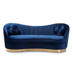 a blue velvet couch with gold trimmings on the arms and back, sitting in front of a white background