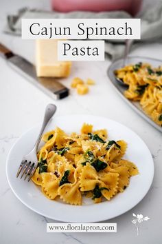 A plate of bow-tie pasta covered in Cajun sauce and spinach leaves with a fork ready to dig in. Pasta For Two, My Recipes