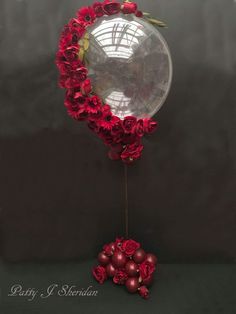 a mirror with red flowers on it next to some balls