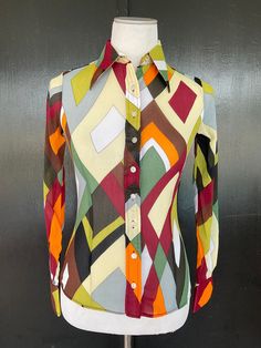 1970s Wayne Rogers blouse. Multicolor almost sheer crepe texture nylon. Nine button front. Two button cuffs. Size 7/8 Measurements  32" bust 24" midriff  30" hem 23" length 22" sleeves 13" shoulders There is a decent amount of stretch to this fabric. Lovely blouse shows beautifully with no wear.  Deadstock item with Bonwit Teller hangtag still attached. Multicolor Retro Print Button-up Top, Colorful Patterned Fitted Long Sleeve Tops, Multicolor Collared Blouse For Fall, Fitted Long Sleeve Tops With Colorful Pattern, Fitted Long Sleeve Top With Colorful Pattern, Fitted Multicolor Retro Print Tops, Colorful Retro Long Sleeve Tops, Colorful Long Sleeve Retro Tops, Fitted Multicolor Tops With Retro Print