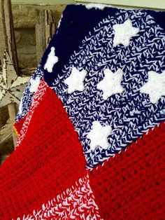 an american flag crocheted afghan sits on a bench